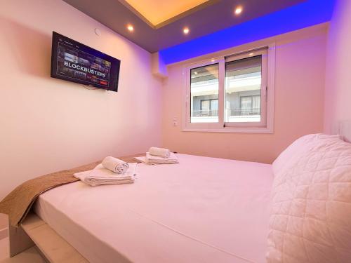 a bedroom with a bed with towels on it at Ilektra Suites by SDR in Paralia Katerinis
