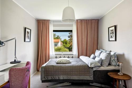 a bedroom with a bed and a large window at Luxurious family villa in a unique location in Djursholm