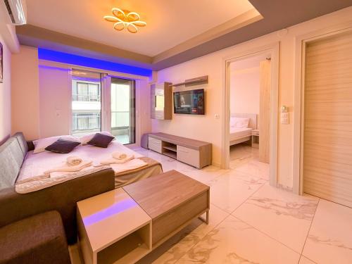 a bedroom with a large bed and a couch at Ilektra Suites by SDR in Paralia Katerinis