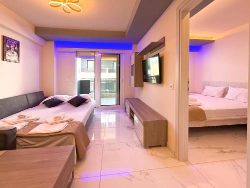 a living room with two beds and a couch at Ilektra Suites by SDR in Paralia Katerinis