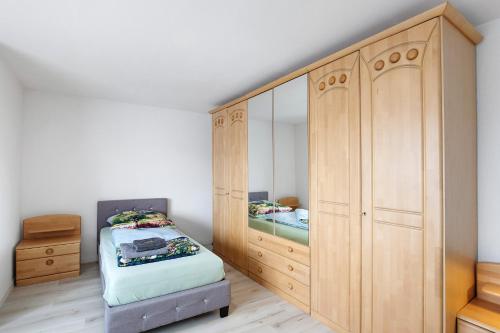 a bedroom with a bed and a large wooden cabinet at Zw -Maria Laach und Nürburgring in Mayen