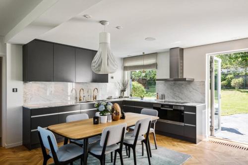 a kitchen with a wooden table and chairs in a kitchen at Luxurious family villa in a unique location in Djursholm