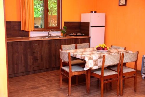 a kitchen with a table with chairs and a white refrigerator at Stay Hovq in Dilijan