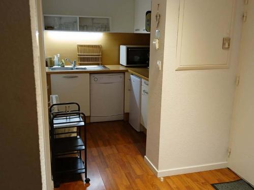 une petite cuisine avec un évier et un micro-ondes dans l'établissement Appartement 2 pièces cabine avec terrasse, piscine et parking - 6 personnes, près de Saint-Lary-Soulan - FR-1-504-131, à Vignec