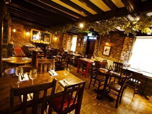 a restaurant with wooden tables and chairs in a room at Woodstock Arms in Woodstock