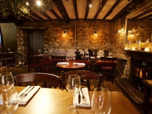 a restaurant with a table and chairs with wine glasses at Woodstock Arms in Woodstock