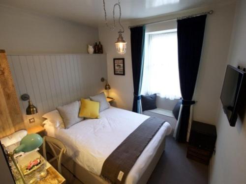 a small bedroom with a bed and a window at Woodstock Arms in Woodstock