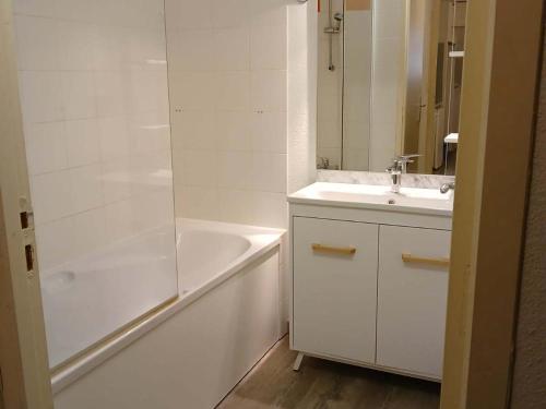 a white bathroom with a tub and a sink and a bath tub at Charmant Appartement 2 Pièces pour 6 à Vignec avec Piscine, Proche Saint-Lary-Soulan et Télécabine - FR-1-504-118 in Vignec