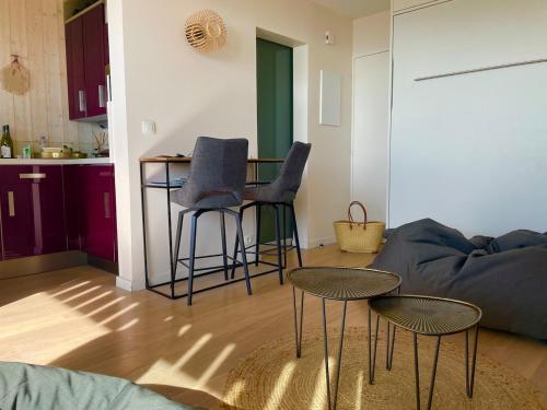 un salon avec un canapé, des chaises et une table dans l'établissement Reveil face aux vagues pour 6 personnes Manahere, à Lacanau