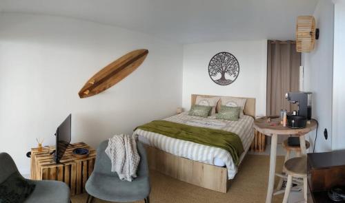 une chambre avec un lit, une table et une chaise dans l'établissement Reveil face aux vagues pour 6 personnes Manahere, à Lacanau