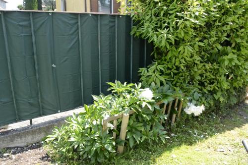 a green fence with some plants and flowers at Il Sole e la Luna B&B in Garda in Garda