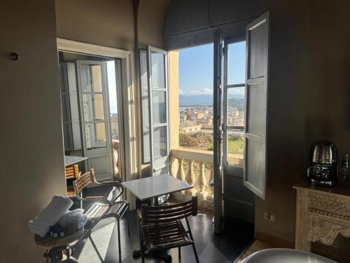 a room with a table and chairs and windows at Saint Amand by Palazzo Boyl in Cagliari