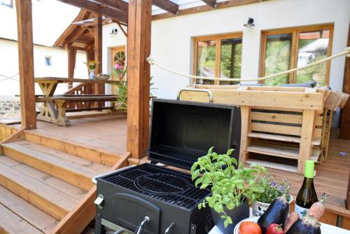a patio with a grill and a table with fruits and vegetables at Iluska Vendégház in Mátraszentimre