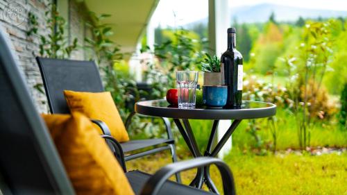 a table with a bottle of wine and glasses on it at Apartamenty Good Time - Belle View - Centrum in Szklarska Poręba