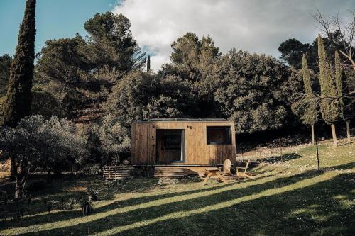 una piccola cabina in legno in un campo alberato di Parcel Tiny House Barroux, entouré par les lamas près du Mont Ventoux a Le Barroux
