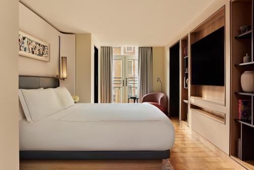 a bedroom with a white bed and a television at The Berkeley, Maybourne in London