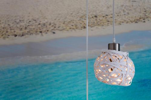 a chandelier hanging over the beach next to the sand at Apartamentos Pou Des Pujols in Es Pujols