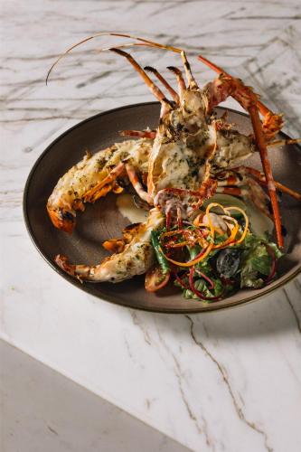 a plate of food with shrimp and salad on a table at Radisson Collection Resort Galle in Galle