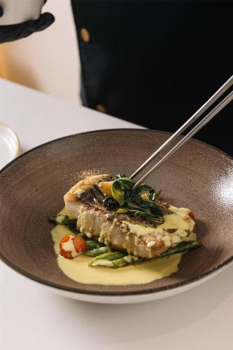 a plate of food with a piece of fish and vegetables at Radisson Collection Resort Galle in Galle