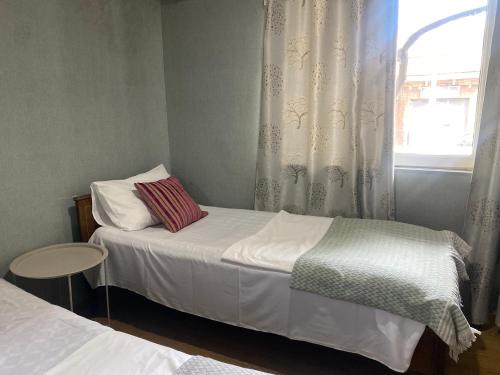 a small bedroom with two beds and a window at Hotel Prime in Mtskheta