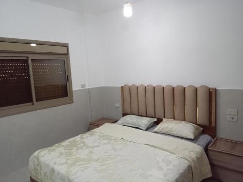 a bedroom with a bed with two pillows and a window at Sky 2 in Jerash