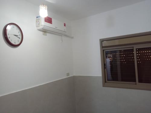a clock on a wall next to a window at Sky 2 in Jerash