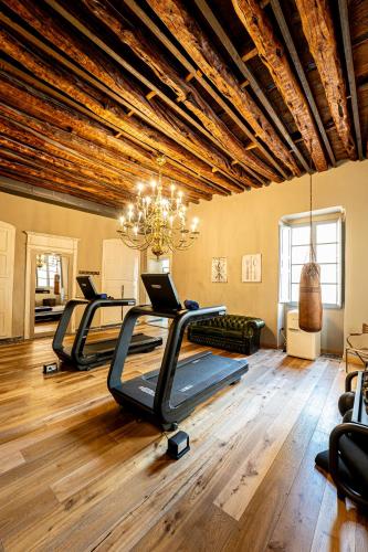 a gym with several treadmills and a chandelier at Saint Amand by Palazzo Boyl in Cagliari