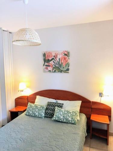 une chambre avec un lit avec deux oreillers dessus dans l'établissement Appt T4 Résidence Le Cordouan 3 étoiles côté Piscine, à Soulac-sur-Mer