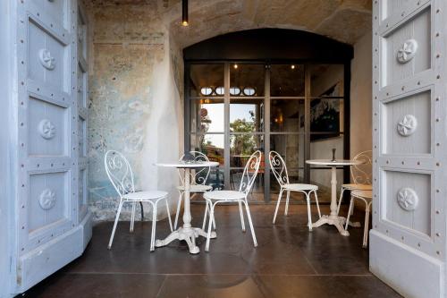 a room with chairs and tables and a window at Saint Amand by Palazzo Boyl in Cagliari