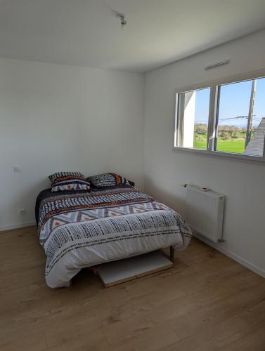 un lit dans une chambre blanche avec une fenêtre dans l'établissement Magnifique maison proche des plages, à Plouzané