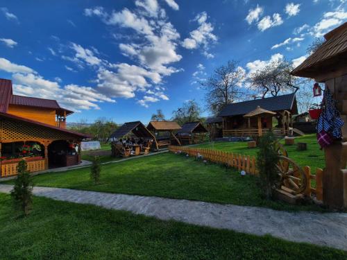 a resort yard with a playground and buildings at Pensiunea Maramu in Breb