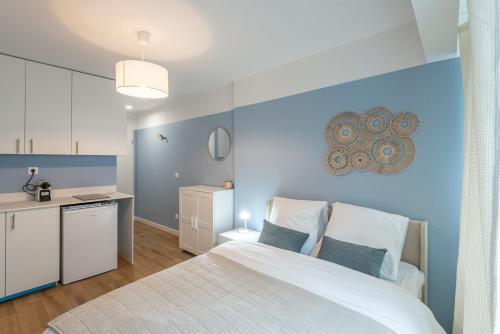 - une chambre avec un lit blanc et un mur bleu dans l'établissement M109 Marquer Studio cozy proche du centre et de la gare, à Annemasse
