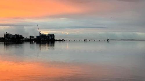 a large body of water with a pier and buildings at Retreat with horse stable views in Redcliffe