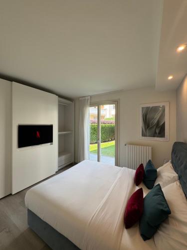 a bedroom with a large bed with red and green pillows at La Vita LakeView - Garden & Pool in Sarnico