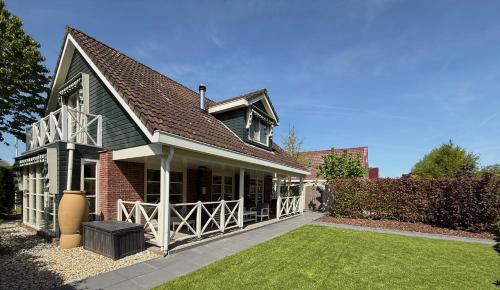 une maison en briques avec un portail et une cour dans l'établissement The Cosy Cottage for Comfort with Sauna and Hottub, à Zeewolde
