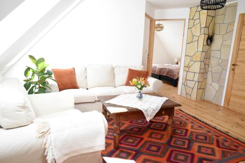 a living room with a white couch and a table at Iluska Vendégház in Mátraszentimre