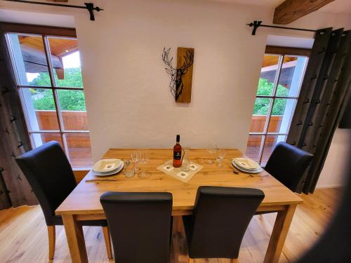 a wooden table with chairs and a bottle of wine at Hörterer Martina | Chiemgau Karte in Grassau