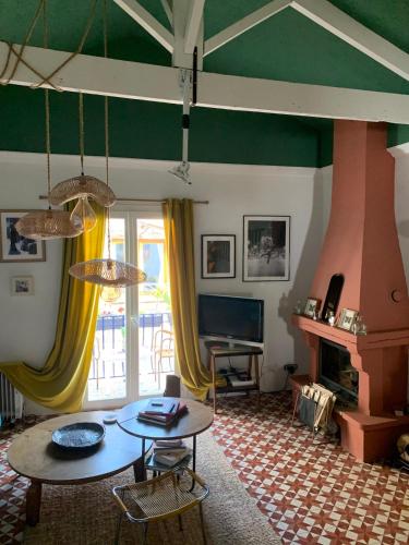 un salon avec une table et une cheminée dans l'établissement Atypical village house in Vence, à Vence