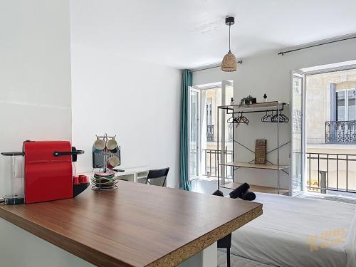 Cette chambre comprend une table et un réfrigérateur rouge. dans l'établissement Studio Lumineux à deux pas du Vieux-Port - Les Frères de la Loc', à Marseille