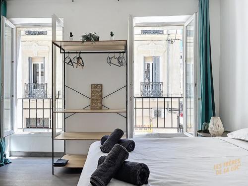 - une chambre avec un lit et 2 serviettes noires dans l'établissement Studio Lumineux à deux pas du Vieux-Port - Les Frères de la Loc', à Marseille