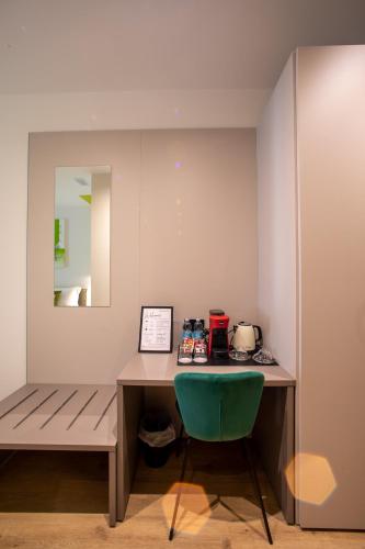 a desk with a green chair in a room at Poetica Verona in Verona