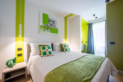a bedroom with a large bed with green and yellow walls at Poetica Verona in Verona