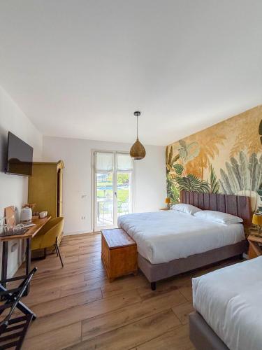 a hotel room with two beds and a desk at Bed and Breakfast Le Giale in Castelnuovo del Garda