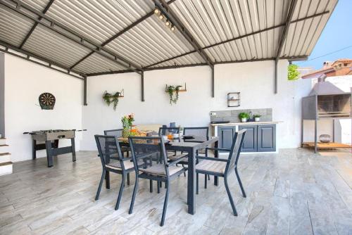 un patio con tavolo e sedie e una cucina di Ferienhaus mit Privatpool für 6 Personen ca 140 qm in Loborika, Istrien Südküste von Istrien a Loborika