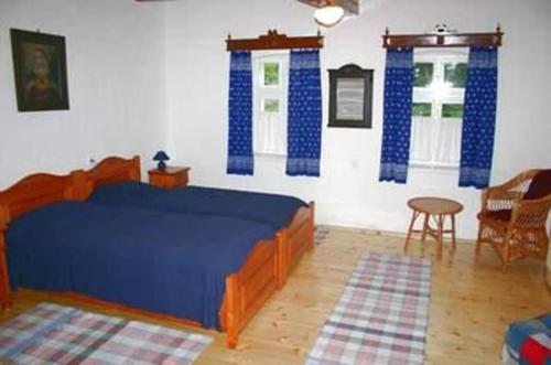 a bedroom with a blue bed in a room at Anna Falusi Vendégház Sarud in Sarud