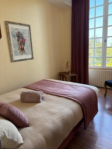 a bedroom with two beds and a window at Domaine familial du château de Ragny in Savigny-en-Terre-Plaine