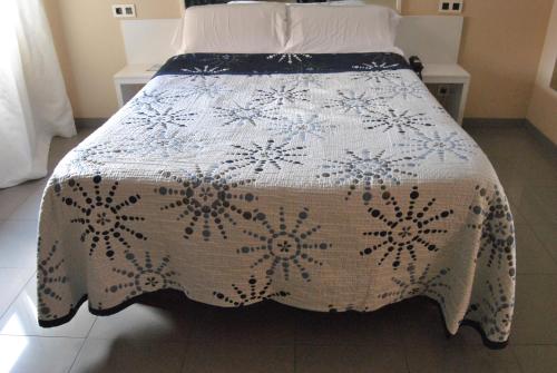 a bed with a black and white bedspread on it at Motel Cancun Oviedo in Llanera