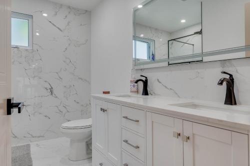 a white bathroom with a toilet and a sink at Room in cozy home in Montréal