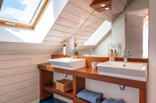 ein Badezimmer mit zwei Waschbecken und einem Dachfenster in der Unterkunft Chambres d'hôtes avec piscine in Arzano