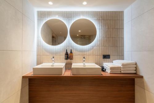 two sinks in a bathroom with two mirrors at Malie House in Utrecht